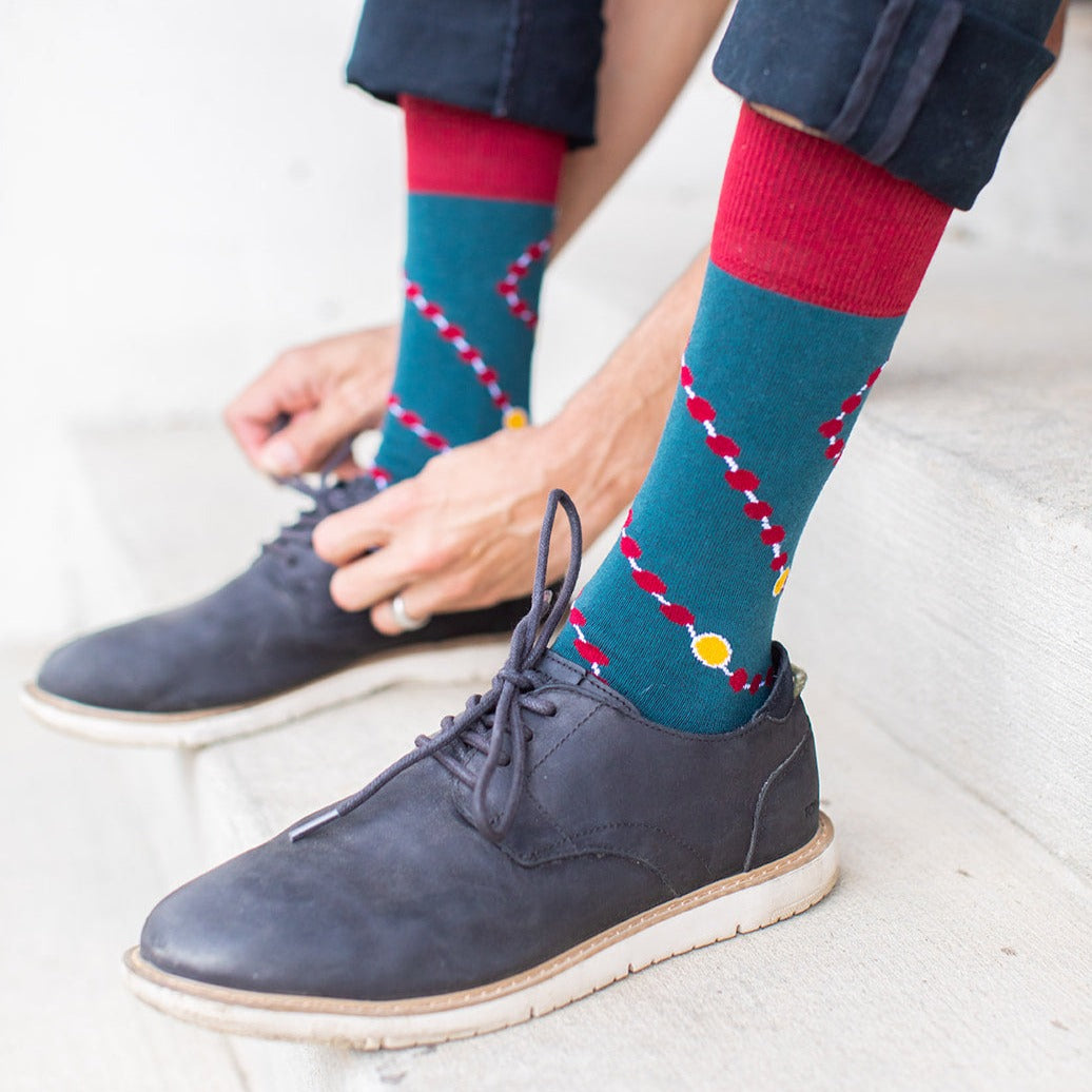 a person wearing a pair of blue shoes and a pair of socks with a design of rosary