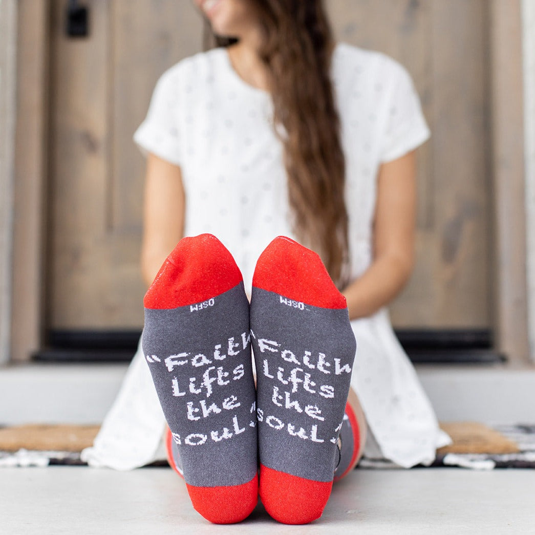 a woman sitting on the floor with her feet up in a pair of socks