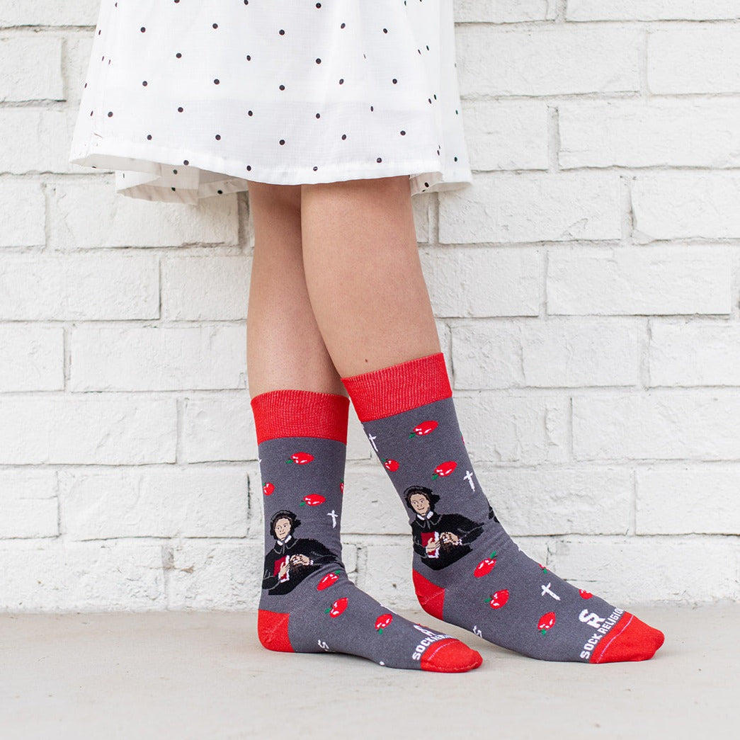 a woman in a white dress and wearing a pair of socks with a picture of St. Elizabeth Ann Seton
