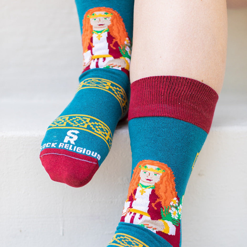 a woman's legs wearing a pair of socks with a picture of St. Dymphna