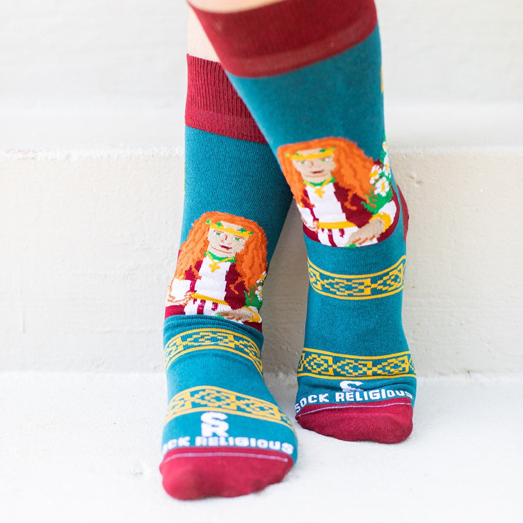 a person wearing a pair of socks with a picture of St. Dymphna