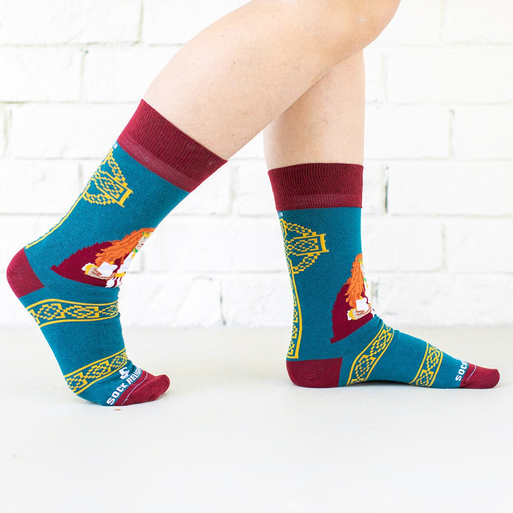 a woman's legs wearing a pair of socks with a picture of St. Dymphna