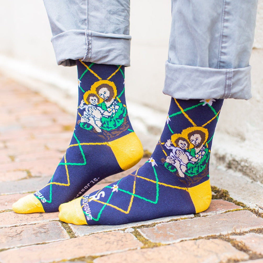 a person standing on brick wearing a pair of socks with St. Joseph socks on them