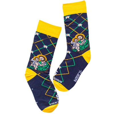 flat image of navy dress socks with St. Joseph and infant Jesus on them, yellow heel, toe, and cuff, lilys and carpenter squares