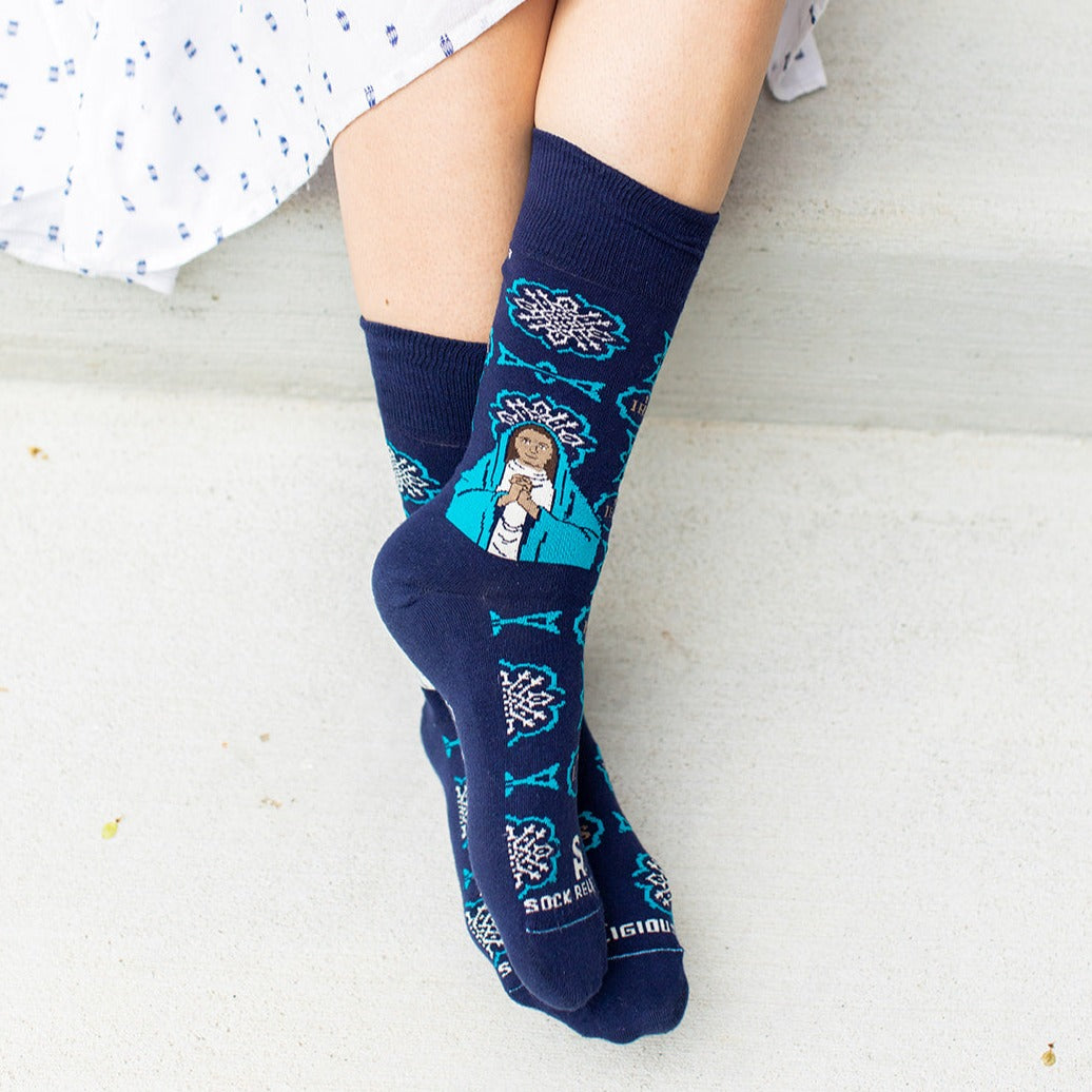 a woman wearing a pair of blue socks with a picture of St. Monica
