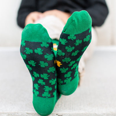 a person wearing green socks with shamrocks on them showing bottom of foot