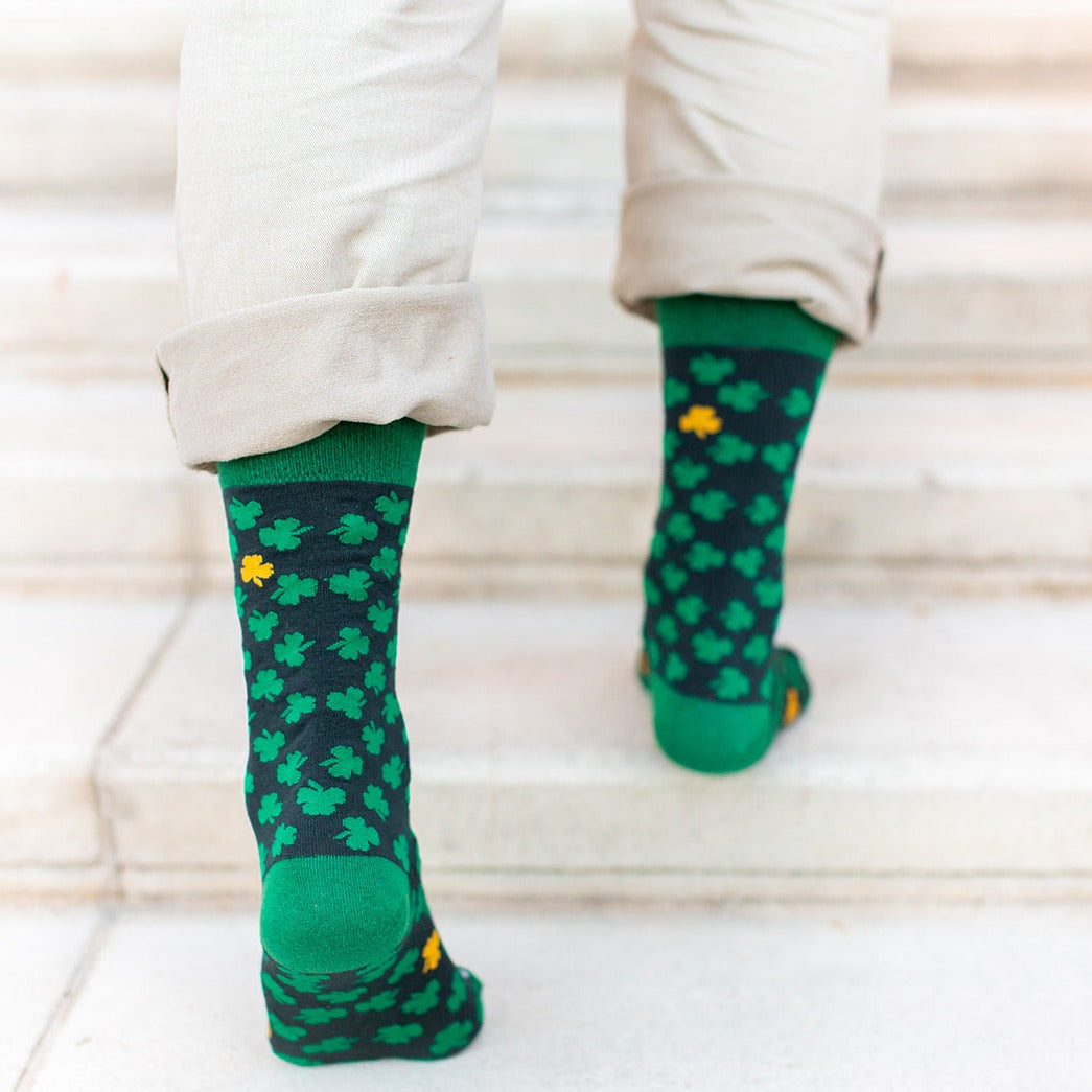 man walking up steps showing back of Green socks with green clovers and St. Patrick of Ireland
