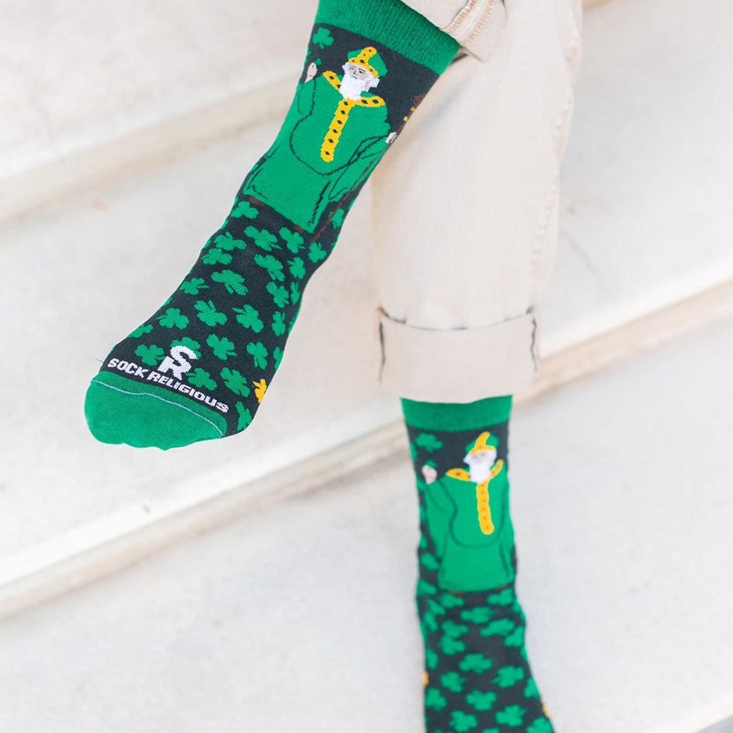 person crossing legs wearing green St. Patrick adult dress socks