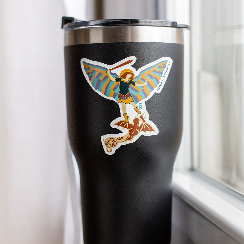 St. Michael the Archangel sticker with words 'defend us in battle' on a black tumbler