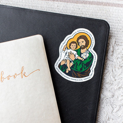 St. Joseph and the infant Jesus with various names of Joseph listed around the outside on a black notebook