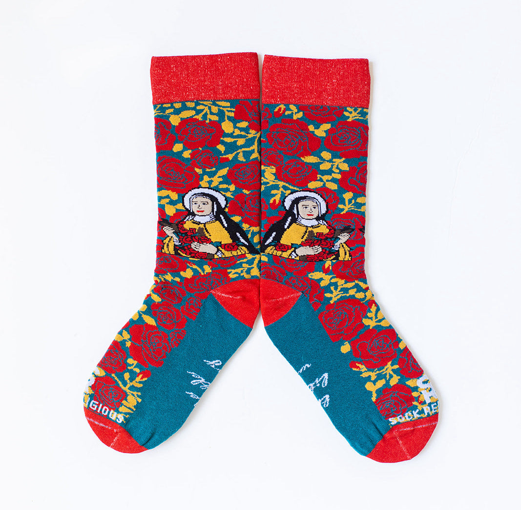 a pair of St. Therese Catholic Sock Religious socks, the background is blue with a bright red rose pattern