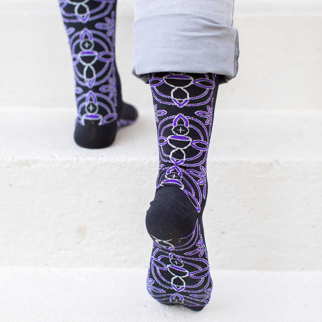 a person standing on a set of stairs wearing purple patterned socks