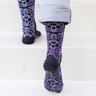 a person standing on a set of stairs wearing purple patterned socks