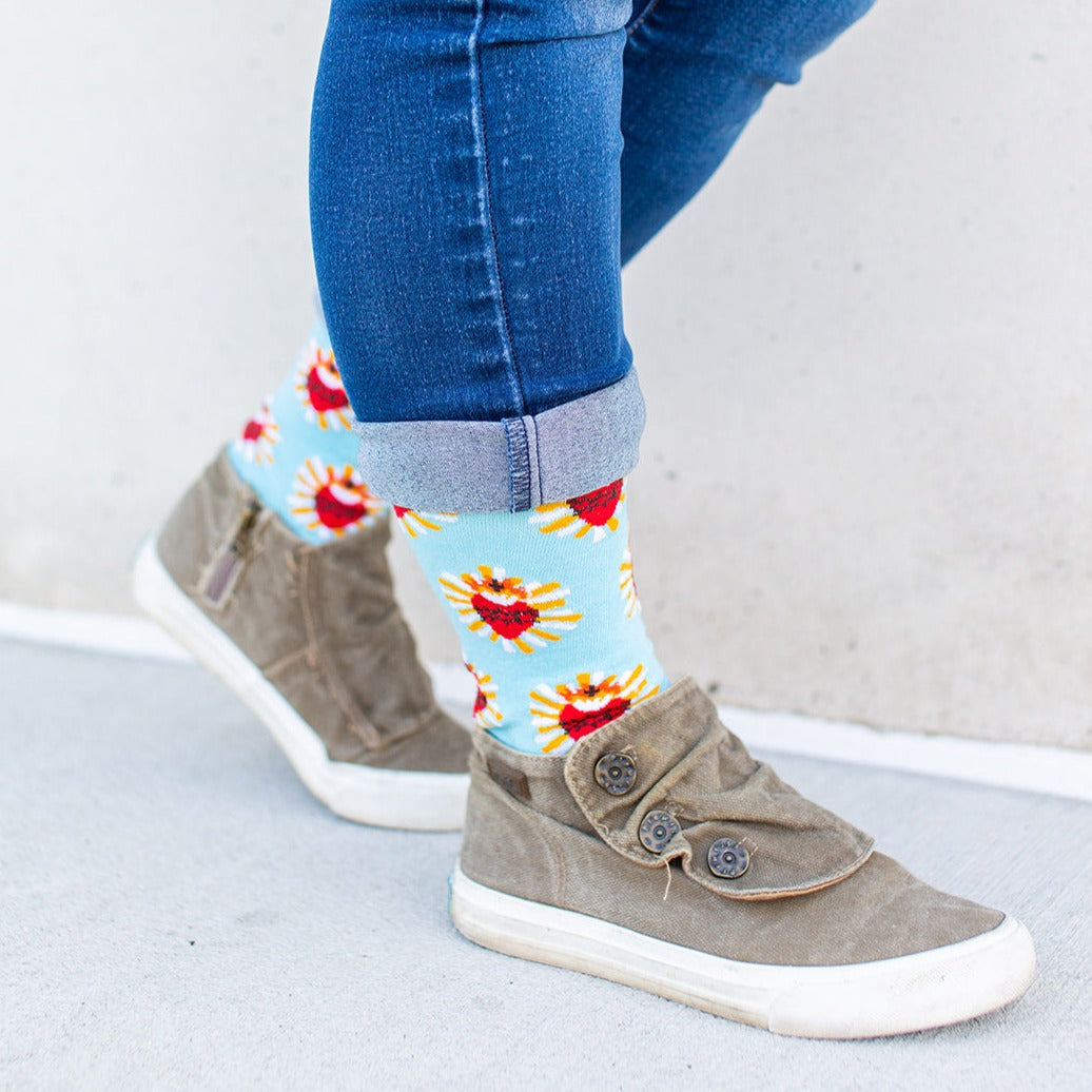 a person wearing a pair of gray shoes a pair of red and blue Sacred Heart socks
