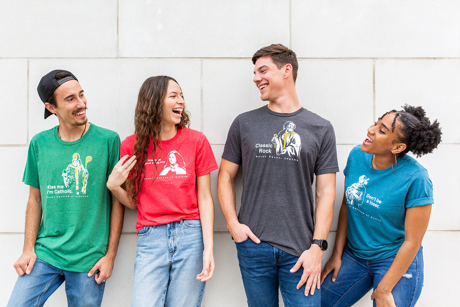 a group of people standing next to each other wearing catholic shirts