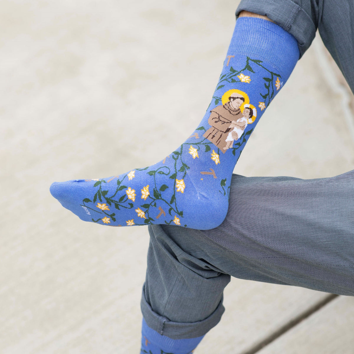 a person wearing a pair of blue socks with a picture of St. Anthony