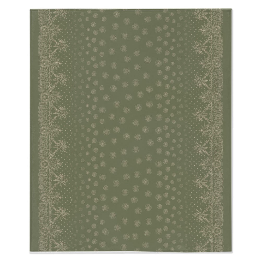 A green and white blanket with a white border, showcasing a gold design of craft symbols by Louis and Zélie laid flat on a white background.