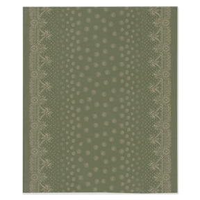 A green and white blanket with a white border, showcasing a gold design of craft symbols by Louis and Zélie laid flat on a white background.