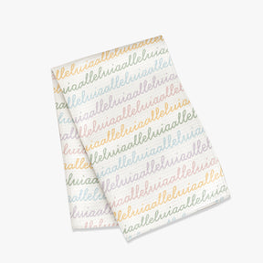 White colored, waffle textured dish towel folded in half with the design that says alleluia, alleluia repeatedly in cursive writing, in colors pastel pink, pastel yellow, pastel blue and pastel green.