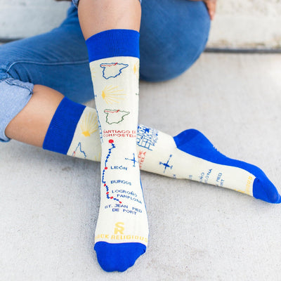 a woman sitting on the ground with her legs crossed wearing a pair of blue and white socks with a map on them