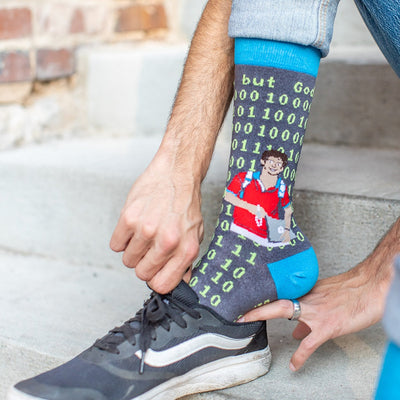 a man putting on a sock with a picture of Bl. Carlo Acutis