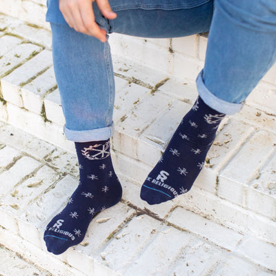 A person sitting on steps wearing A pair of blue socks with a deign on it