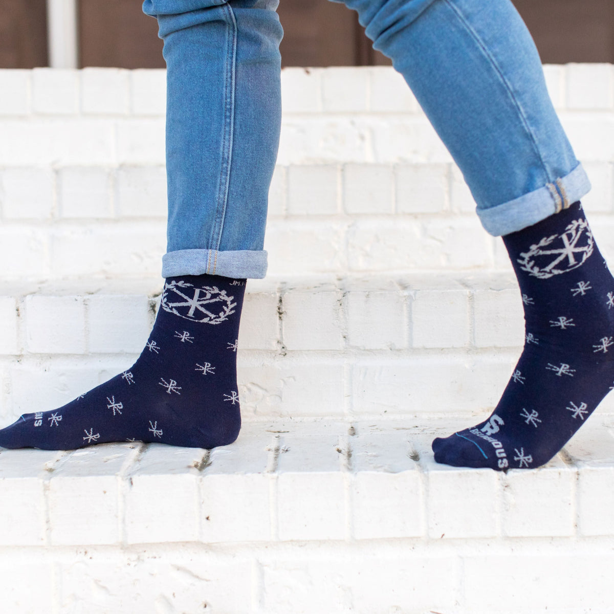 A person sitting on steps wearing A pair of blue socks with a deign on it