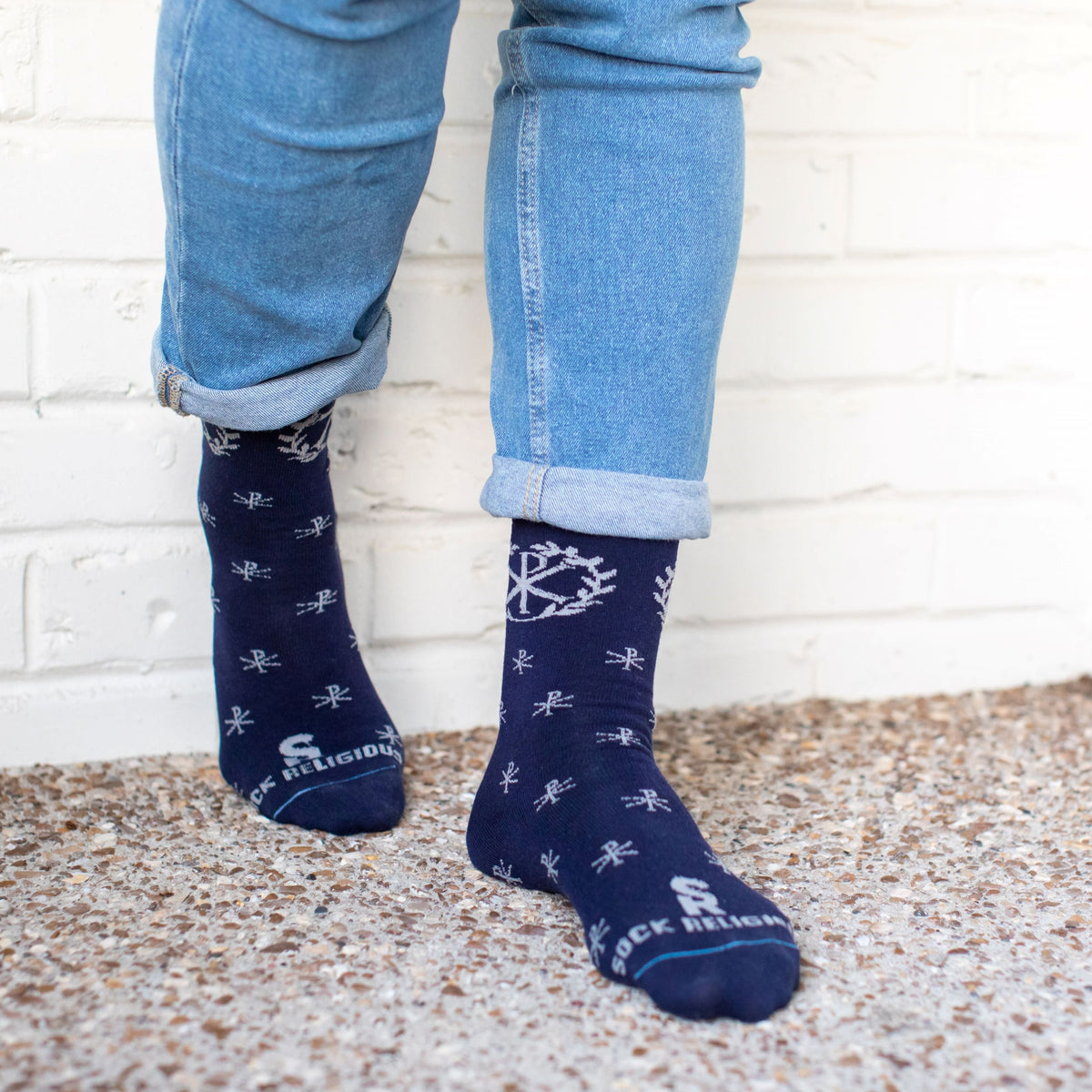A person standing wearing A pair of blue socks with a deign on it