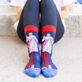 a woman sitting wearing a pair of catholic dress socks featuring the Divine Mercy Image of Jesus