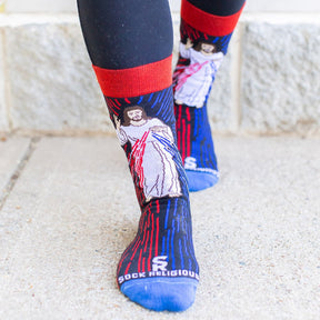 a woman standing wearing a pair of catholic dress socks featuring the Divine Mercy Image of Jesus