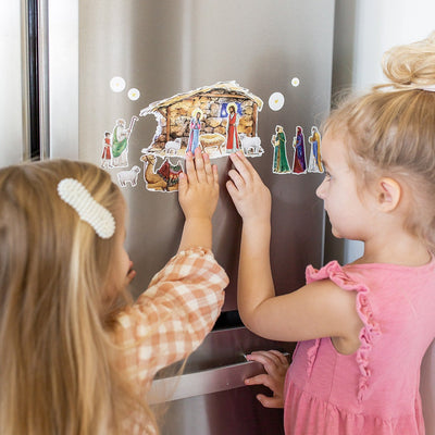 little girls playing with Nativity Cling set on a fridge