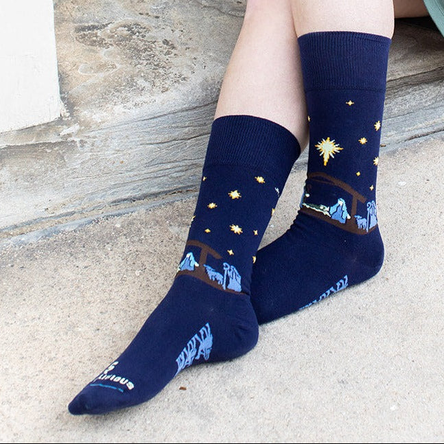 a woman sitting on a step with her legs crossed with the nativity socks on
