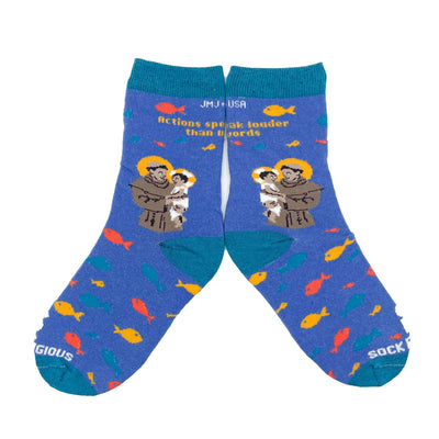 blue socks featuring St. Anthony holding the infant Jesus with several fish and the words "Actions speak louder than words" along the calf flat lay