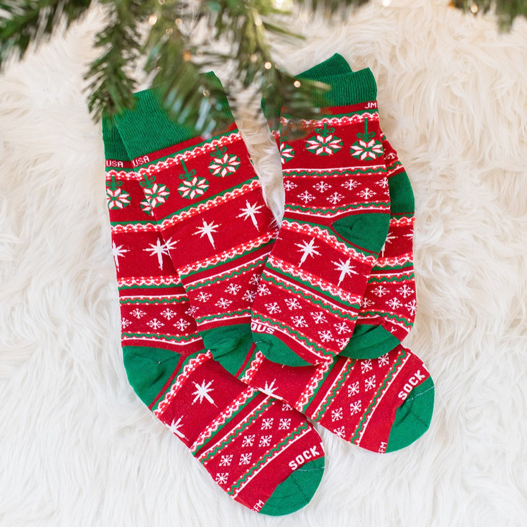 a pair of red and green socks sitting on top of a white rug