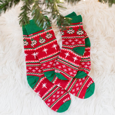 a pair of red and green socks sitting on top of a white rug