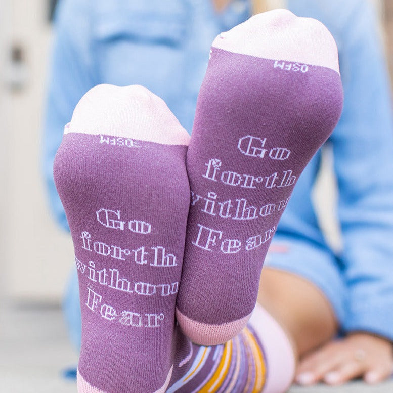 a person wearing purple socks with words on them