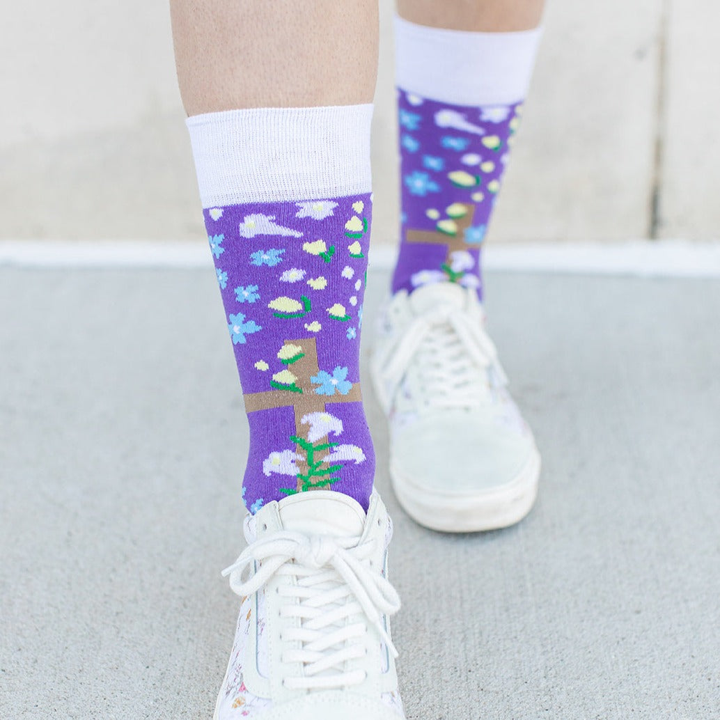 a woman wearing a pair of purple socks with a cross and flowers on it