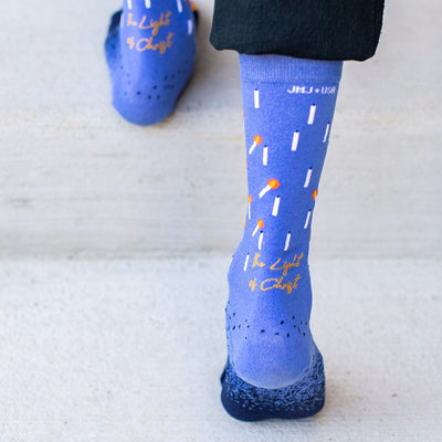 a person wearing a pair of blue socks with candles on them
