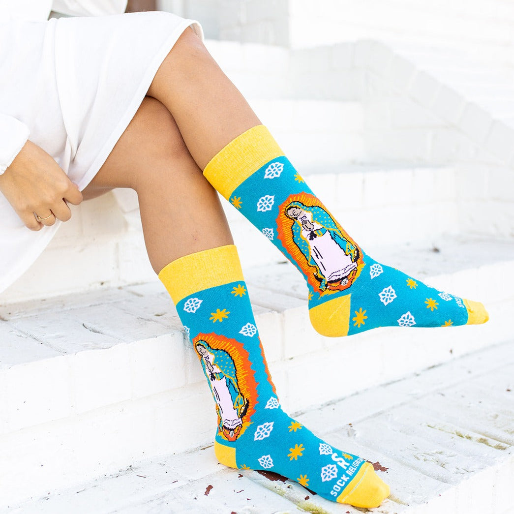 a woman sitting on a step with her legs crossed wearing Our Lady of Guadalupe Socks