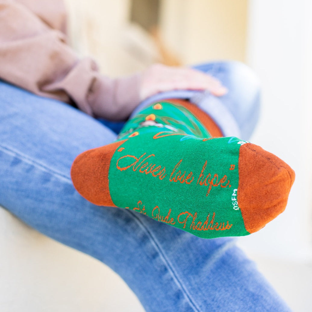 a person sitting on a couch with a green and orange sock