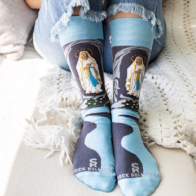a person wearing a pair of socks with the image of Our Lady of Lourdes