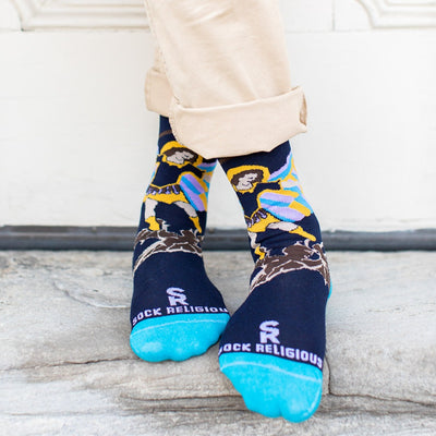 man wearing navy blue socks with St. Michael the Archangel slaying a demon and the words 'defend us in battle' on the bottom of the foot