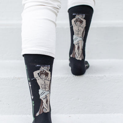 a person standing on a set of stairs wearing socks with a picture St. Sebastian