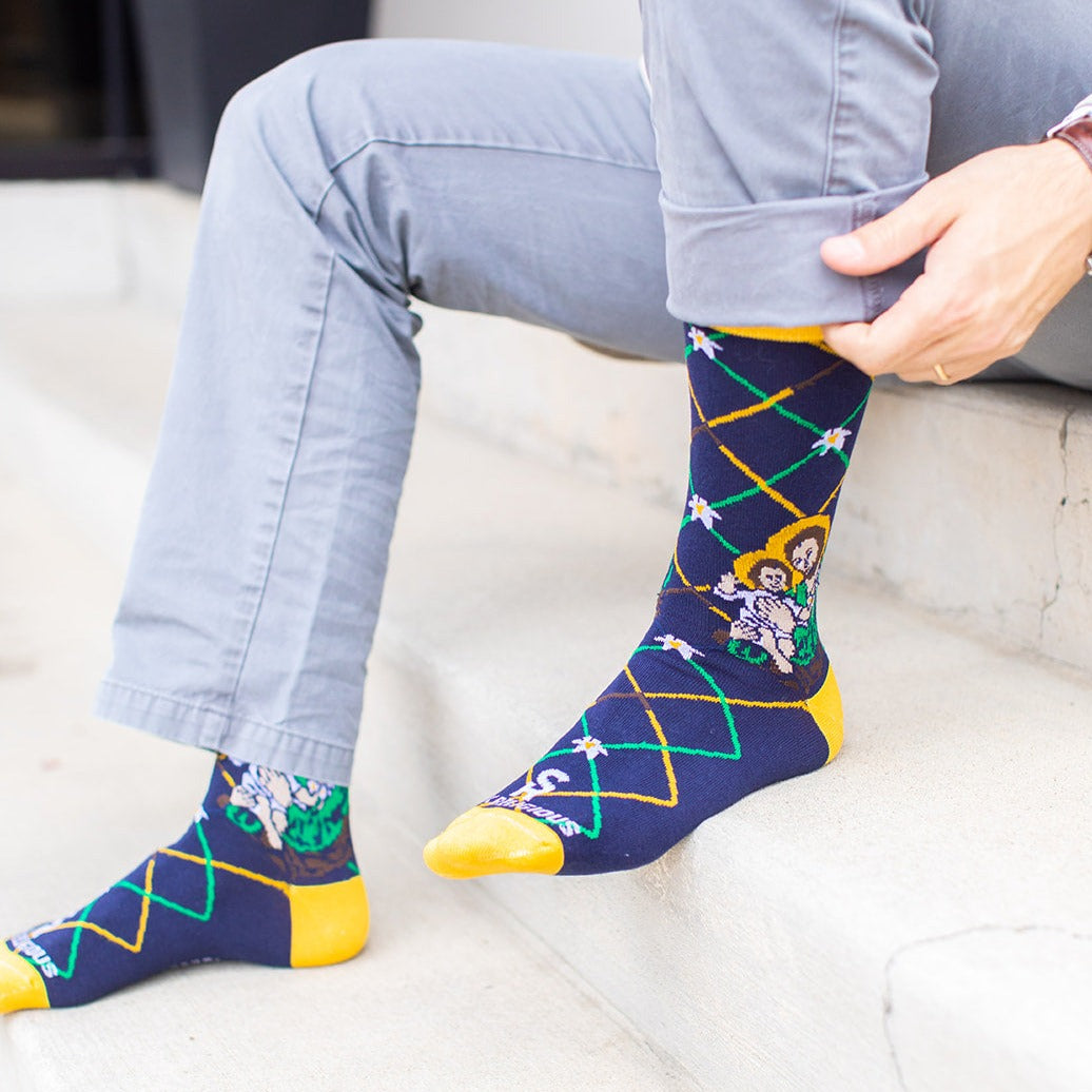 a man sitting on a step wearing a pair of St. Joseph socks