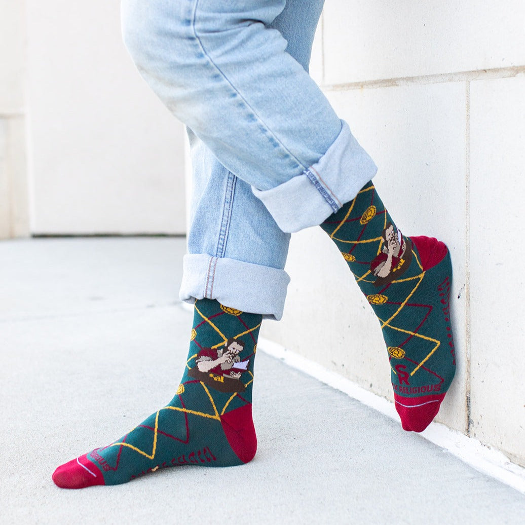 a person wearing a pair of socks with a picture of St. Matthew