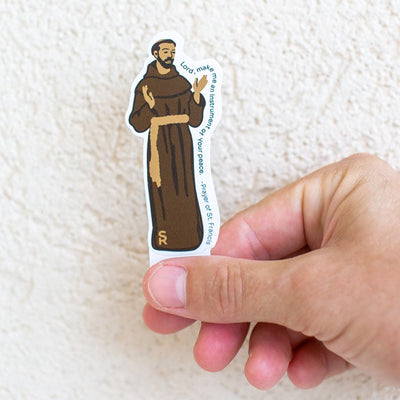 picture of someone holding a St. Francis of Assisi sticker that says "Lord make me an instrument of your peace" - Prayer of St. Francis