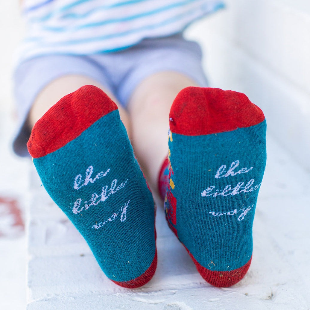 a child's feet wearing St. Therese socks that say 'the little way' on the bottom of the foot