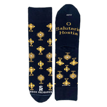 A stylish pair of black socks featuring shiny golden monstrances and text